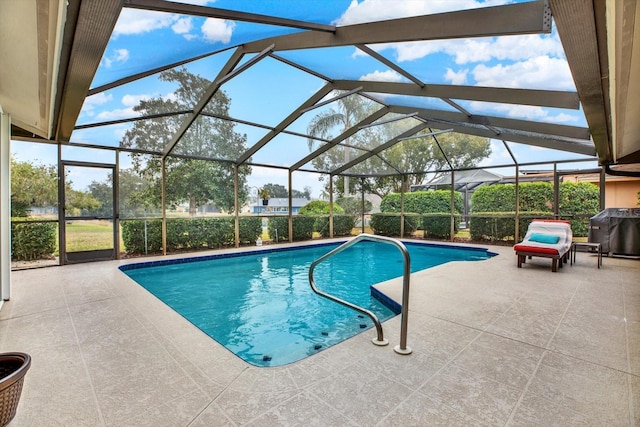 view of swimming pool featuring a grill, a patio area, and glass enclosure