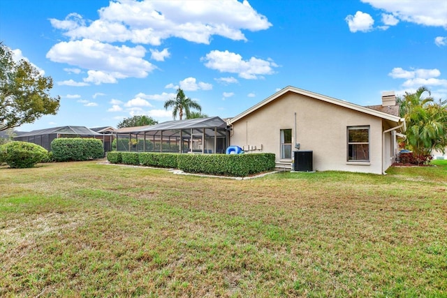 back of property featuring a yard, a lanai, and central AC unit