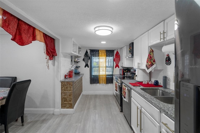 kitchen featuring a textured ceiling, fridge, stainless steel dishwasher, light hardwood / wood-style floors, and white cabinets