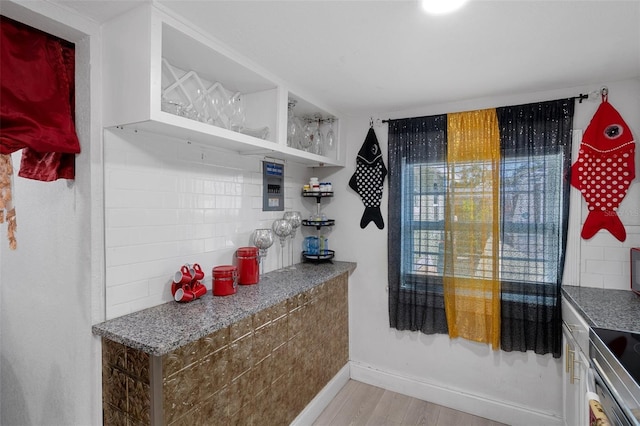 kitchen featuring stove, backsplash, and light hardwood / wood-style floors