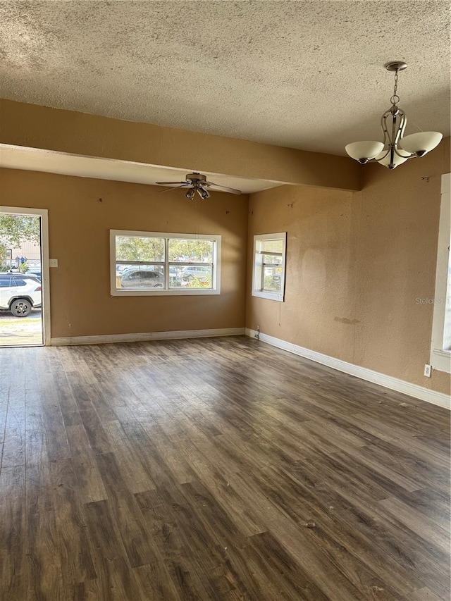 empty room with dark wood-style floors, baseboards, a textured ceiling, and ceiling fan with notable chandelier