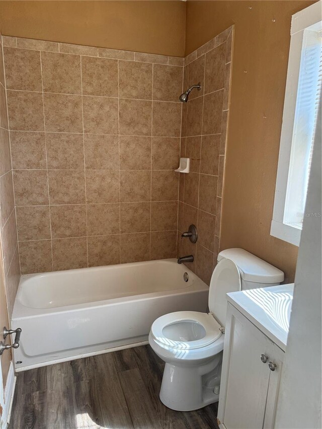 full bathroom with toilet, shower / bath combination, wood finished floors, and vanity