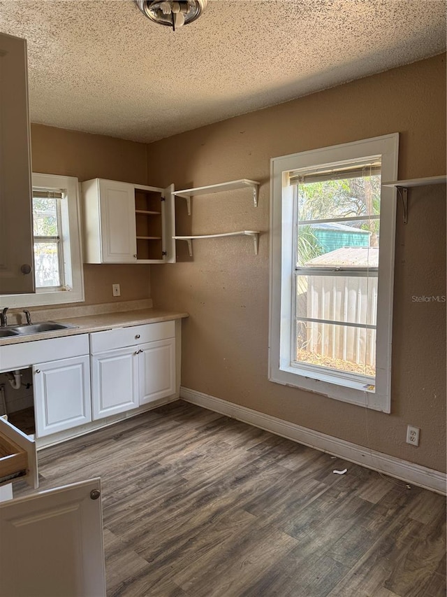 kitchen with light countertops, white cabinets, a sink, and open shelves