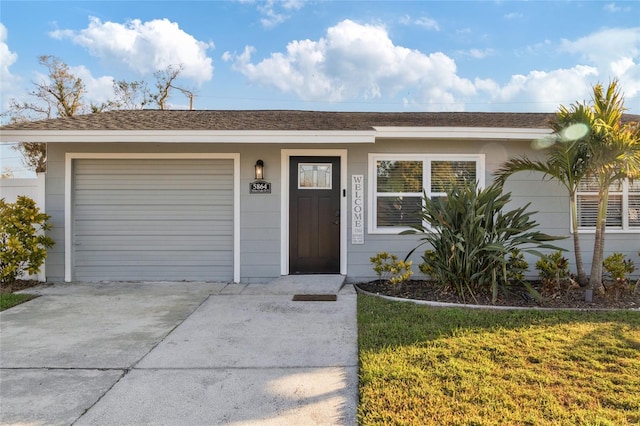 ranch-style home with a garage and a front yard