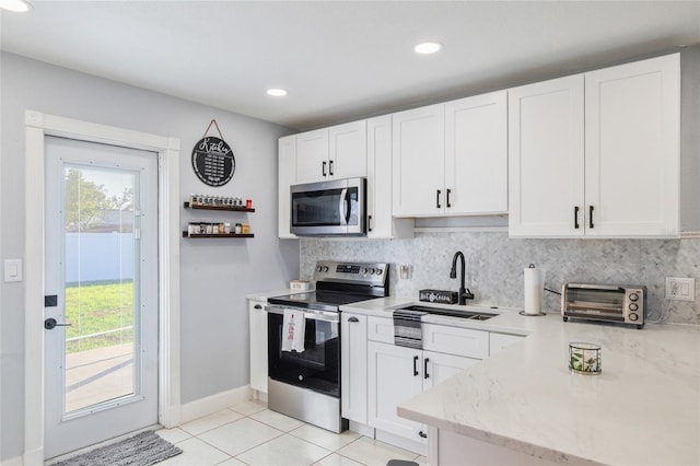 kitchen featuring white cabinetry, stainless steel appliances, and backsplash