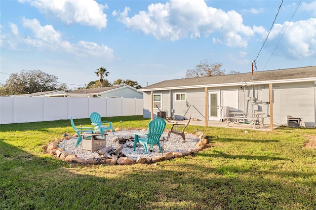 rear view of house with a patio area, a lawn, and an outdoor fire pit