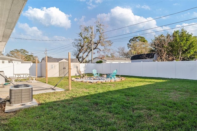 view of yard with cooling unit, a storage shed, a fire pit, and a patio