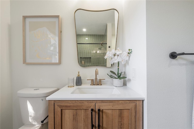 bathroom featuring vanity, a shower with shower door, and toilet