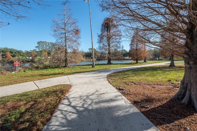 view of property's community with a yard and a water view