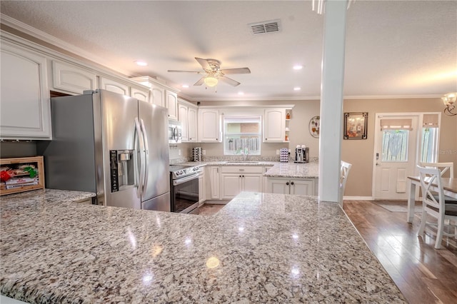 kitchen with stainless steel appliances, light stone countertops, sink, and white cabinets