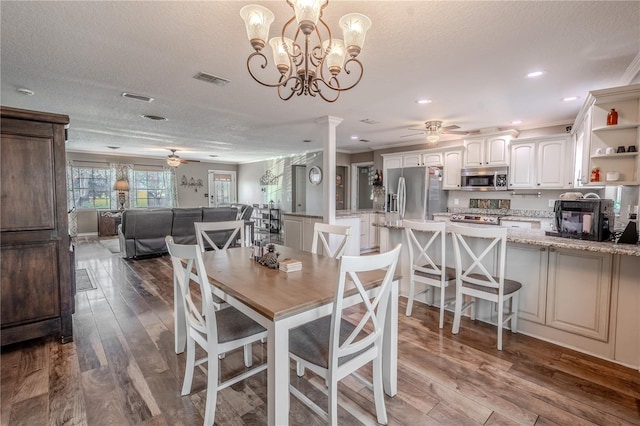 dining area with ceiling fan, light hardwood / wood-style floors, decorative columns, and a textured ceiling