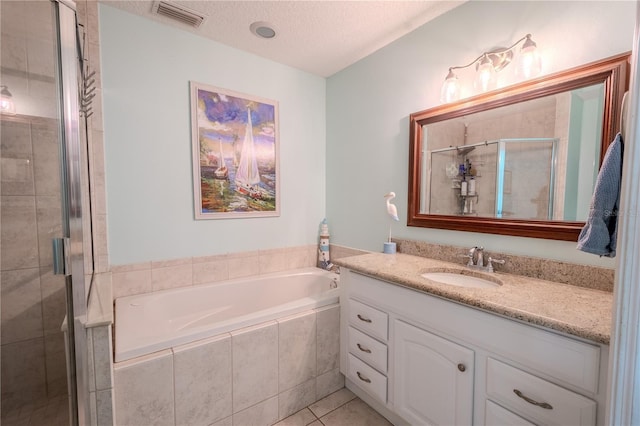 bathroom with tile patterned flooring, vanity, a textured ceiling, and plus walk in shower