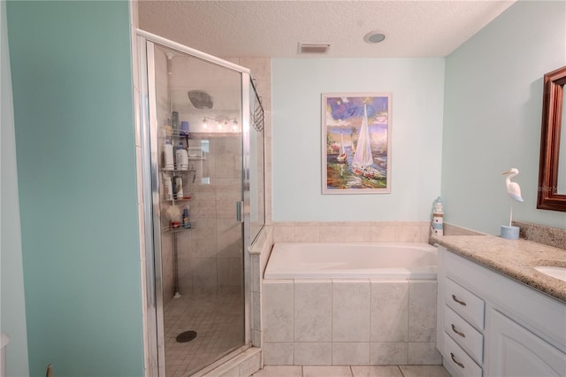 bathroom with tile patterned flooring, vanity, shower with separate bathtub, and a textured ceiling