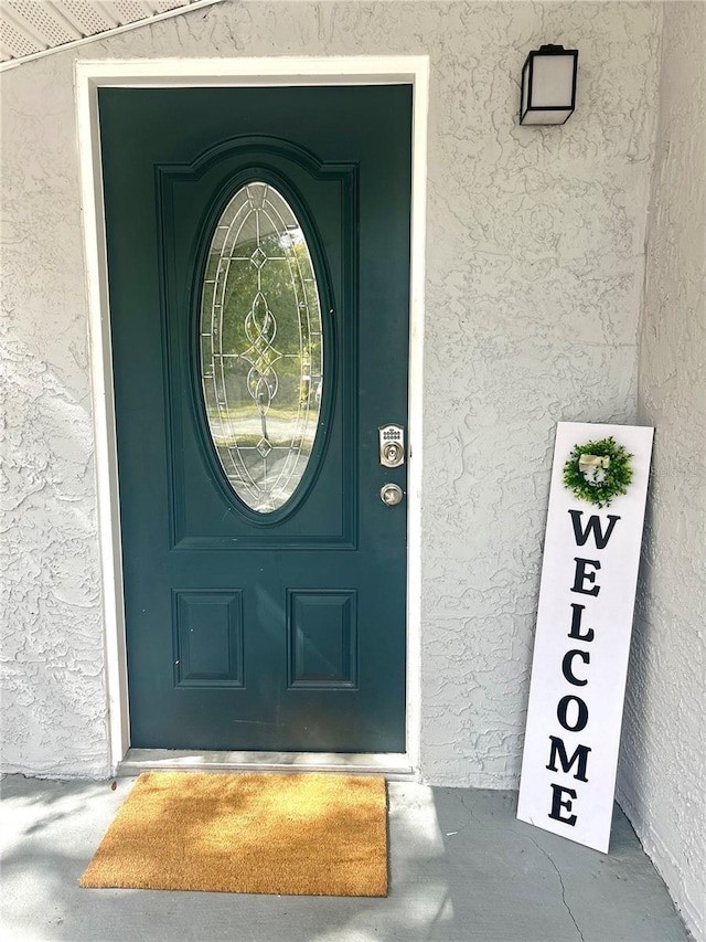 entrance to property featuring stucco siding