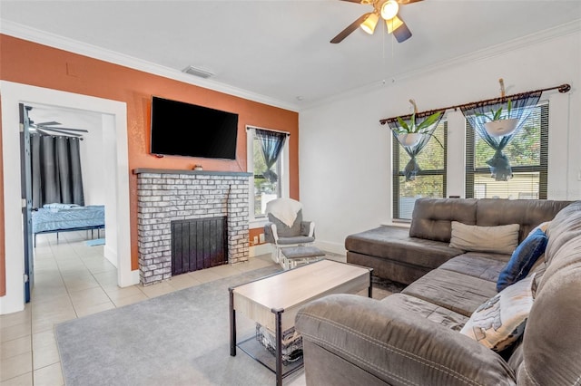 living room with light tile patterned floors, crown molding, a fireplace, and ceiling fan