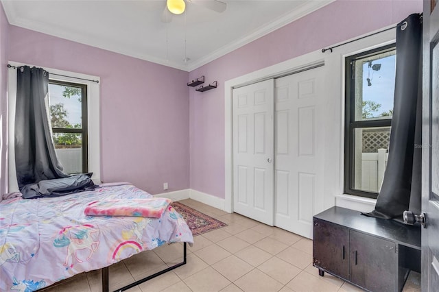 tiled bedroom with ornamental molding, ceiling fan, and a closet