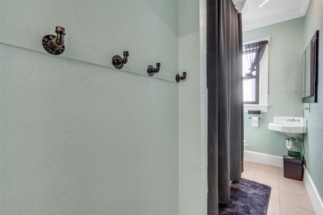 bathroom with tile patterned flooring and ornamental molding