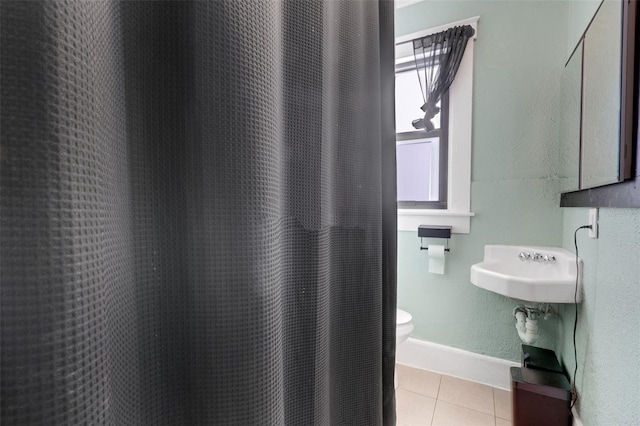 bathroom with tile patterned floors, toilet, and a shower with shower curtain