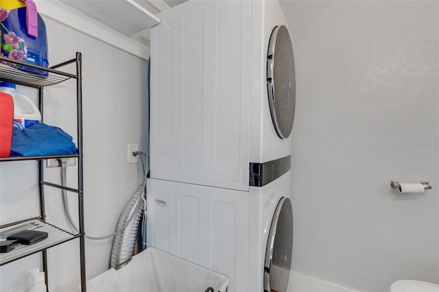 clothes washing area featuring stacked washer and clothes dryer