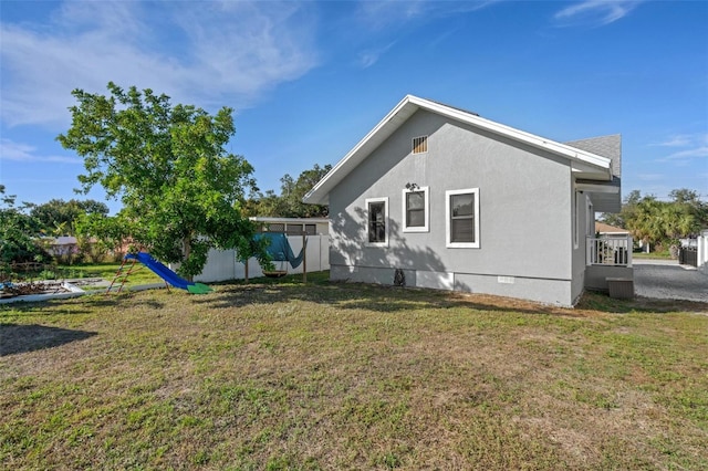 view of side of home with a yard