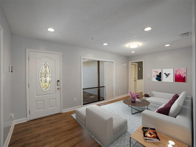 living room featuring dark hardwood / wood-style floors and a textured ceiling