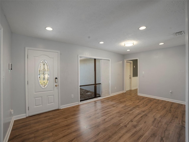 entryway with dark wood-type flooring and a textured ceiling