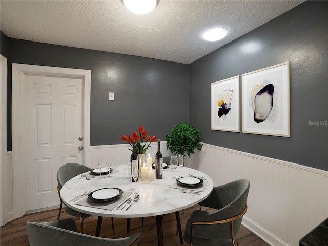 dining space featuring dark hardwood / wood-style floors and a textured ceiling