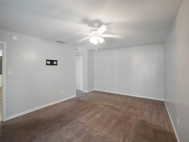 empty room featuring ceiling fan, carpet floors, and a textured ceiling