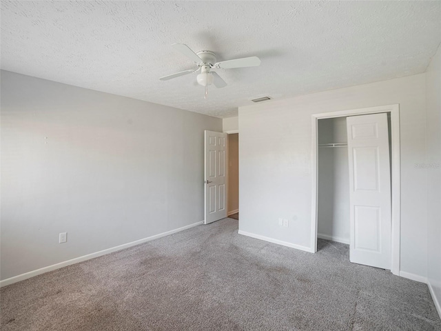 unfurnished bedroom with ceiling fan, a closet, a textured ceiling, and carpet