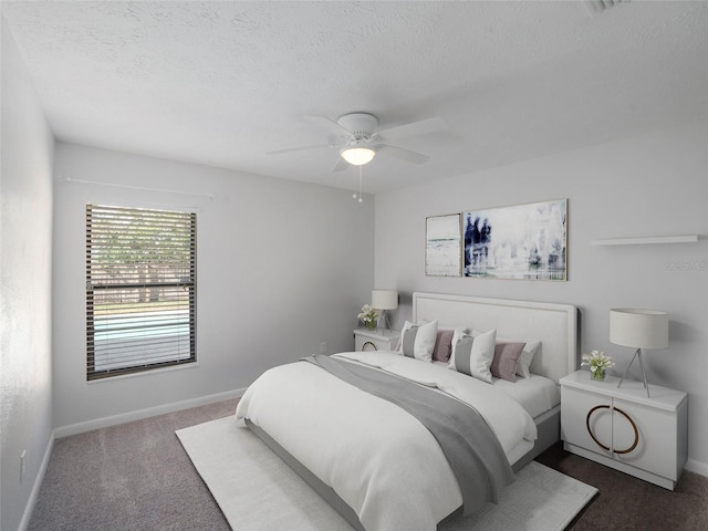 bedroom with ceiling fan, a textured ceiling, and dark colored carpet