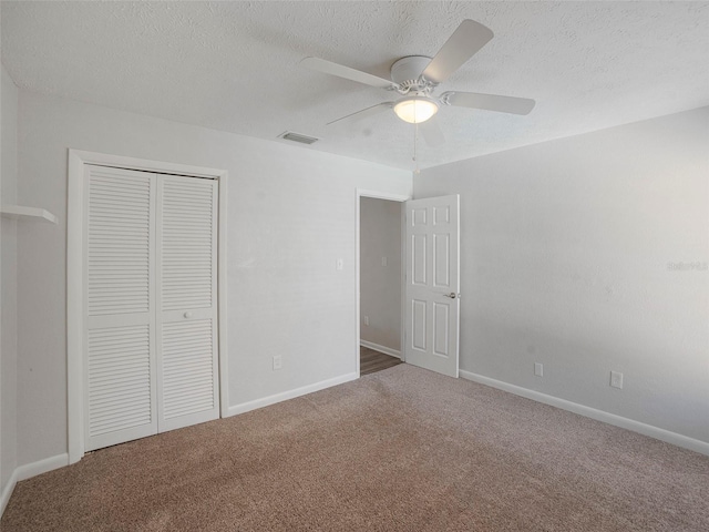 unfurnished bedroom featuring ceiling fan, a closet, carpet, and a textured ceiling