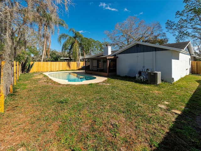 view of yard featuring a fenced in pool, central AC unit, and a sunroom