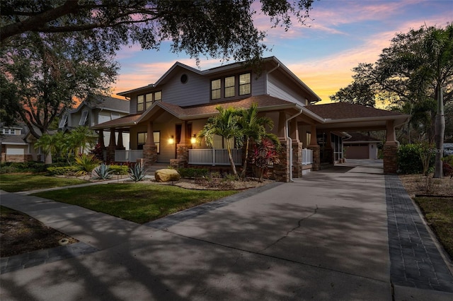 view of front of house with a porch, a garage, a yard, and a carport