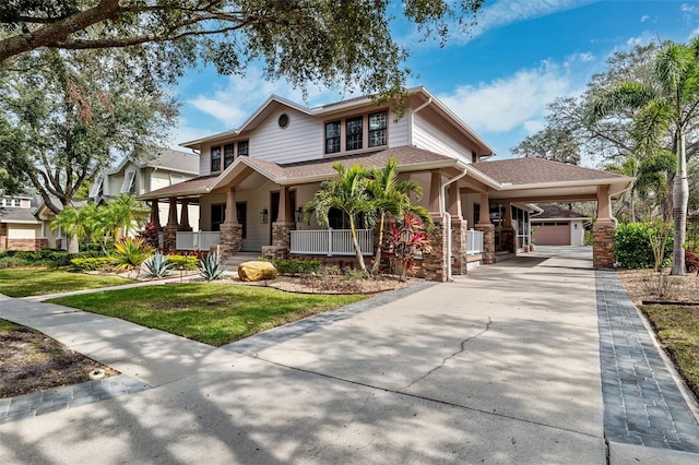 view of front of house featuring a porch, a garage, a carport, and a front lawn