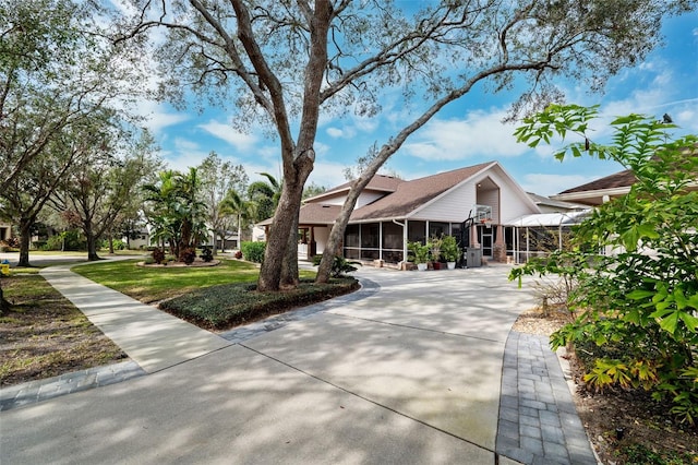 view of front of home featuring a front lawn, a lanai, and a sunroom