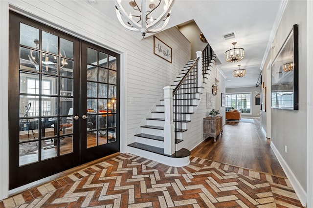 entrance foyer with an inviting chandelier and french doors