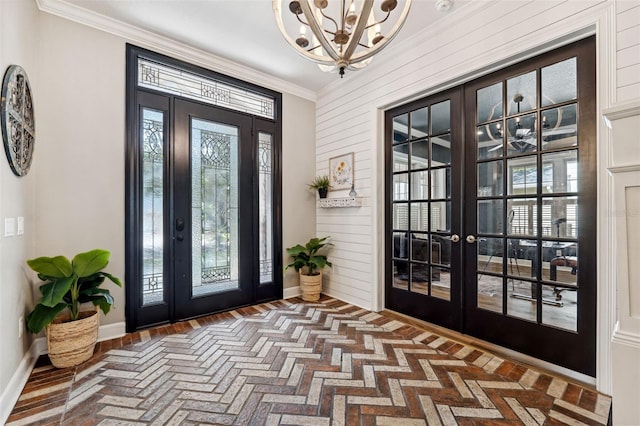 foyer with ornamental molding, a chandelier, and french doors