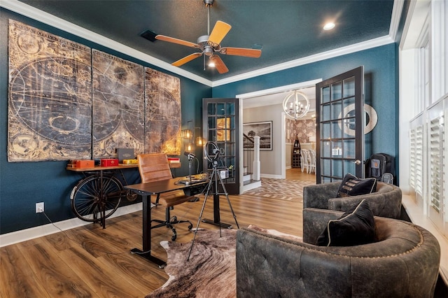 home office featuring ceiling fan with notable chandelier, ornamental molding, and hardwood / wood-style floors