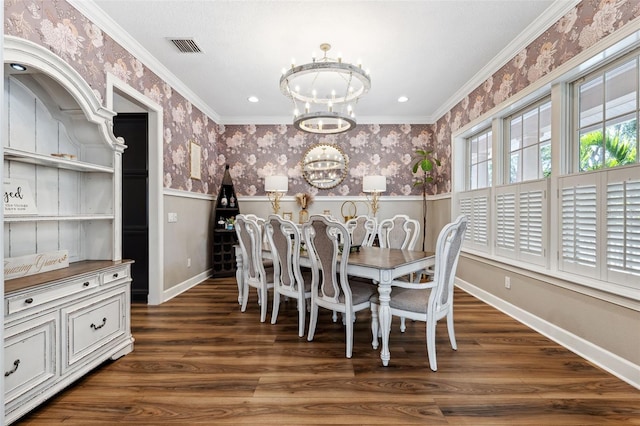 dining room with crown molding, dark hardwood / wood-style floors, and a chandelier