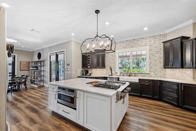 kitchen with white cabinetry, sink, hanging light fixtures, a center island, and stainless steel appliances