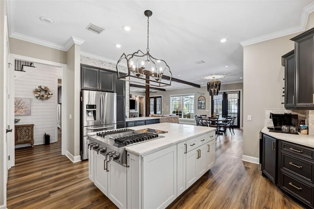 kitchen featuring dark wood-type flooring, decorative light fixtures, a center island, appliances with stainless steel finishes, and white cabinets