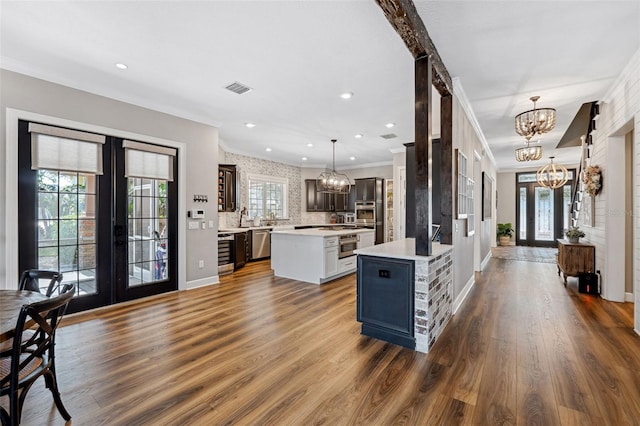 kitchen with a center island, pendant lighting, a notable chandelier, and french doors