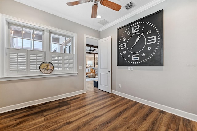 empty room featuring dark wood-type flooring, ceiling fan, and ornamental molding