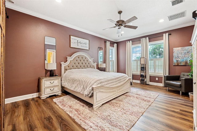 bedroom featuring crown molding, wood-type flooring, and ceiling fan