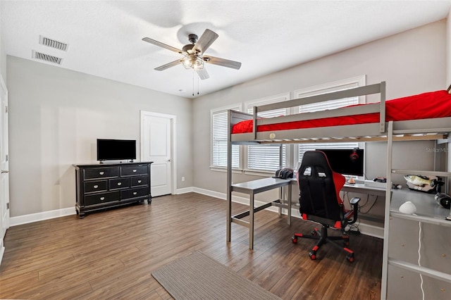 bedroom featuring ceiling fan, dark wood-type flooring, and a textured ceiling