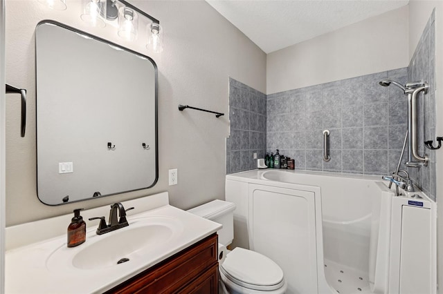 bathroom featuring vanity, a bath, a textured ceiling, and toilet