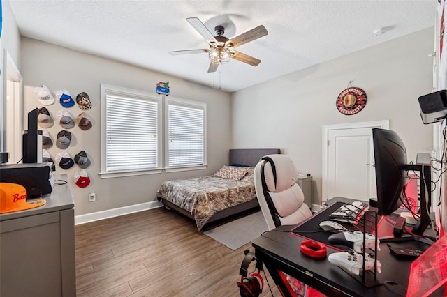 bedroom featuring dark wood-type flooring, ceiling fan, and a textured ceiling