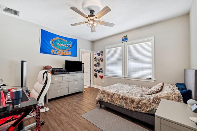 bedroom with hardwood / wood-style floors, a textured ceiling, and ceiling fan