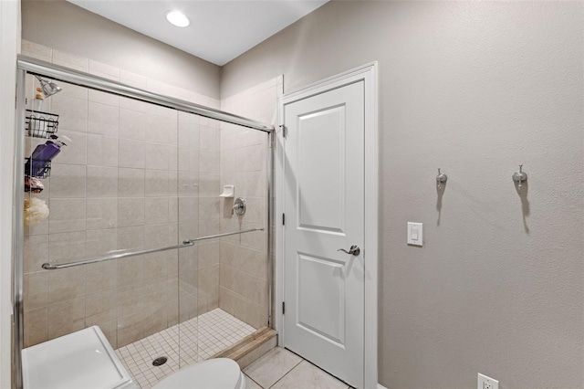 bathroom featuring toilet, tile patterned floors, and walk in shower