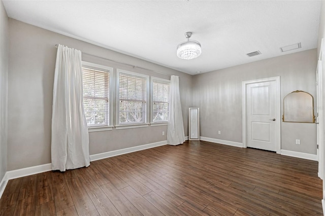 unfurnished room with dark wood-type flooring